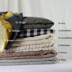 a stack of folded shirts with labels on them showing the different colors and sizes for each shirt