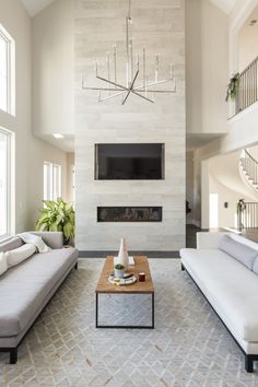 a living room with two couches and a coffee table in front of a fireplace