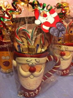 some candy canes are wrapped in plastic and decorated like santa's helpers