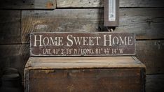 a wooden sign that says home sweet home next to a thermometer on a bench