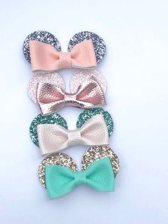 three bows with sequins on them are sitting next to each other in front of a white background