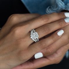 a woman's hand with white manicured nails and a ring on her finger