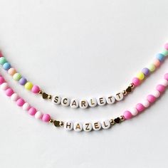 Add a burst of vibrant charm to your little one's outfit with our Bright Colorful Beads Name Necklace! This delightful piece combines the timeless elegance of dainty gold name beads with an array of eye-catching, colorful hued beads. Your child's name is spelled out in gold and adorned with a captivating spectrum of colors, creating a personalized gift that will surely bring smiles. This necklace would make a perfect birthday gift for little girls.  Perfect for Easter too! Colorful acrylic beads strung on wire and accented with Gold letter Beads, 18k plated heart beads and 18k plated gold ball beads. 18K gold hearts or 18K round ball beads.   Choose which style you would like from the drop down menu along with the length of the necklace. Necklace is packaged for gift giving. To see more Ki Cute Personalized Multicolor Charm Necklaces, Playful Pink Charm Necklaces For Friendship, Fun Pink Adjustable Charm Necklace, Playful Pink Charm Necklace For Friendship, Fun Pink Adjustable Charm Necklaces, Pink Adjustable Fun Charm Necklace, Playful Beaded Charm Necklaces For Gifts, Playful Beaded Charm Necklace For Gifts, Playful Beaded Charm Necklaces As Gifts