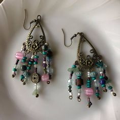 I made these spunky dangling earrings with lots of different kinds of beads, some are real crystal beads and some are just normal. I put in beads from some bracelets ive broken including a Chinese coin style bracelet. The base of these earrings include great detail and a floral design. Multicolor Metal Dangle Crystal Earrings, Bohemian Crystal Earrings With Colorful Beads For Gift, Bohemian Style Crystal Drop Earrings With Dangling Beads, Eclectic Adjustable Dangle Jewelry, Metal Beaded Earrings With Faceted Beads For Gifts, Adjustable Metal Earrings With Faceted Beads, Unique Metal Beaded Dangle Earrings, Bohemian Beaded Earrings With Round Metal Beads, Vintage Dangle Beaded Earrings For Festival