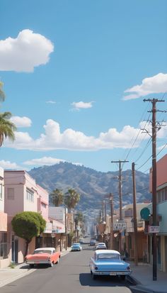 cars are parked on the street in front of buildings with mountains in the back ground