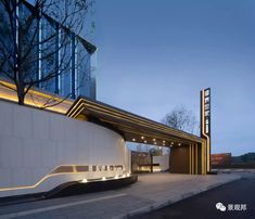 the entrance to an office building with lights on it's front and side walls