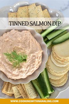 a plate with crackers, celery and hummus on it that says thinned salmon dip