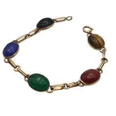 This Vintage Symmetallic Bracelet Features Intricately Carved Scarabs Set In Sterling Silver With 14k Gold Vermeil Accents. Each Scarab, Crafted From Vibrant, Colored Stones, Adds A Touch Of Elegance And Historical Significance. The Bracelet's Classic Design Is A Nod To Ancient Egyptian Artistry, Making It A Timeless Piece For Collectors. Intricate Scarab Design Sterling Silver & 14k Gold Colored Stone Scarabs Classic Clasp Closure 7.25 Inches Length Bracelet Measures 7.25 Inches In Length. Nice Scarab Bracelet, Colored Stones, Colored Stone, Gold Overlay, Ancient Egyptian, Womens Jewelry Bracelets, Gold Vermeil, Timeless Pieces, Stone Color