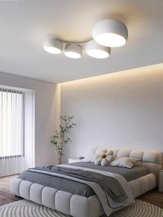 a modern bedroom with white walls and wood flooring, round lights above the bed