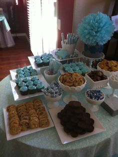 a table topped with lots of desserts and cupcakes