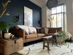 a living room filled with furniture and a large painting on the wall next to a window