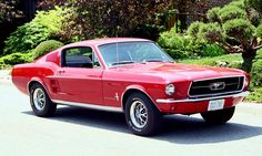 an old red muscle car parked on the street