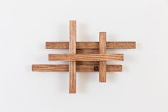 a cross made out of wood sitting on top of a white wall