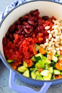 a pot filled with vegetables and beans on top of a table