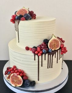 a white cake topped with fruit and drizzled chocolate