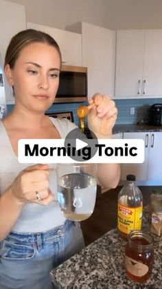 a woman holding a glass in her right hand with the words morning tonic on it