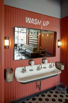 a bathroom with a sink and mirror on the wall next to a red striped wall