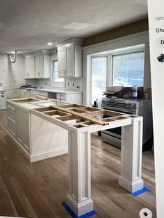 an image of a kitchen being remodeled with white cabinets and blue tape on the floor