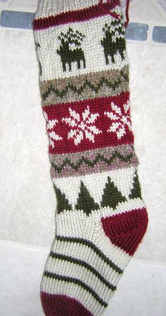 a knitted christmas stocking laying on the floor