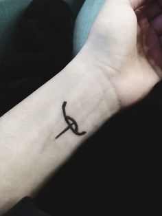 a person's arm with a small tattoo on the left side of their wrist