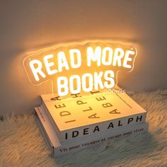 a stack of books with the words read more books on it and an illuminated book light