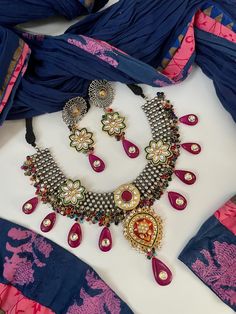 Designer Festive Fusion Meenakari Kundan stones studded Dual tone oxidized Necklace set. Dark Pink Long Bead drops with multicolor onyx makes this piece of jewelry so festive. Drawstring adjustable. Matching earrings included. Ethnic jewelry. Festive Jewelry. Navratri Jewelry. ✅ WHAT GOES IN  👉🏻Premium Quality raw materials. 👉🏻Super light weight earrings. ✅Check our collection here https://www.etsy.com/shop/KKsCulture ✅Contact Us if you need help : Email: kksculture [!at] gmail.com | Phone : Multicolor Dual-tone Temple Jewelry, Multicolor Temple Jewelry, Heavy Multicolor Jewelry For Ceremonial Occasions, Silver Jeweled Temple Necklace For Festivals, Traditional Silver Jeweled Bridal Necklace, Bold Multicolor Ceremonial Jewelry, Multicolor Intricate Design Jewelry For Navratri, Multicolor Jewelry With Intricate Design For Navratri, Multicolor Intricate Jewelry For Navratri