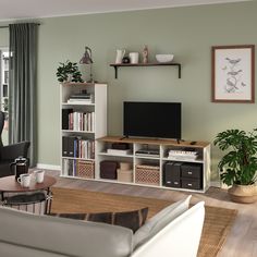 a living room filled with furniture and a flat screen tv on top of a wooden shelf