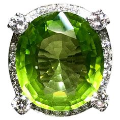 This absolutely spectacular cocktail ring is centered by a very impressive 18.53ct natural, bright electric green peridot surrounded by 1.08cttw in G-H color Vs1-2 clarity round diamonds. All stone weights are stamped inside of the shank. Dimensions/Weight: Ring measures .90” by .75” and weighs 19.7g. Size 6.5 (sizable). Condition: All stones are secure and in perfectly wearable condition. R-GASV Ballerina Ring, Electric Green, Baguette Diamond Rings, Peridot Stone, Diamond Cocktail Rings, Modern Ring, Green Peridot, Marquise Diamond, Christmas Photo