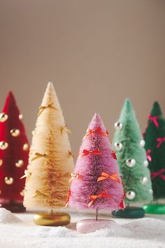 small christmas trees are lined up on a table