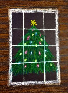 a chalk drawing of a christmas tree in a window sill on a wooden table