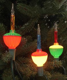 three colorful lights are hanging from a christmas tree