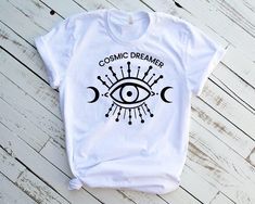 Hi! Welcome to our store, Cosmic Dreamer Women's Shirt * 100% cotton tee * original design * printed in our studio in Miami, FL UNISEX Unisex t-shirt fits like a well-loved favorite, featuring a crew neck, short sleeves, and designed with superior airlume combed and ring-spun cotton that acts as the best blank canvas for printing. CARE INSTRUCTIONS We recommend washing inside out in cold or warm water with like colors. Dry on low to medium heat or hang to dry. Please, do not use bleach or oxycle Eye Shirt, Spiritual Shirts, Instagram Tags, Inspirational Shirt, White Elephant Gifts, Miami Fl, Nurse Gifts, Psychic, The Dreamers