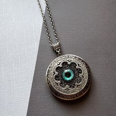 Large Locket Dragon Eye Necklace ☻Locket ~ Large, Decoratively Styled ~ Measures 1.77 inches round See Photos for size comparison against American quarter Chain: ~ Silver Plated YOU CHOOSE YOUR CHAIN LENGTH during checkout ☻More Lockets Here: https://www.etsy.com/shop/FashionCrashJewelry/search?search_query=lockets&order=date_desc&view_type=gallery&ref=shop_search ☻Link to The ENTIRE SHOP: https://www.etsy.com/shop/FashionCrashJewelry?ref=shopsection_shophome_leftnav&ga_search_qu Vintage Round Pendant Jewelry For Festivals, Antique Silver Spiritual Jewelry, Vintage Locket Jewelry For Festivals, Handmade Antique Silver Pendant Locket Necklace, Vintage Festival Locket Jewelry, Bohemian Engraved Round Locket Necklace, Bohemian Handmade Jewelry For Keepsake, Handmade Bohemian Keepsake Jewelry, Bohemian Handmade Keepsake Jewelry