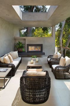 a living room with wicker furniture and a fire place in the center is shown