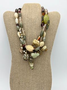 Vintage Sage Cream Heavy Art Glass Beaded Mixed Materials Multi Strand Necklace This is a heavy necklace measuring 17 1/2 inches long. This eclectic, artsy necklace is comprised of unique mixed material beads and charms including: glass beads, various stones, shell, mother of pearl, faux pearls and an a carved jade charm.  It is multicolor with the main color theme being sage green and cream.  The necklace was most likely handmade. It is in excellent vintage condition showing very little signs of wear with no damage that I can find. Please see photos for details and feel free to contact me with questions. Czech Glass Large Beads Multi-strand Jewelry, Multi-strand Czech Glass Jewelry With Large Beads, Unique Multi-strand Gemstone Beads, Multicolor Czech Glass Necklace One Of A Kind, Colorful Double Strand Beaded Necklaces, Bohemian Long Glass Necklace, Unique Double Strand Colorful Beaded Necklaces, Bohemian Czech Glass Beads And Cabochons For Jewelry Making, Bohemian Czech Glass Beads For Jewelry Making