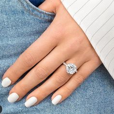 a woman's hand with white manicured nails and a diamond ring