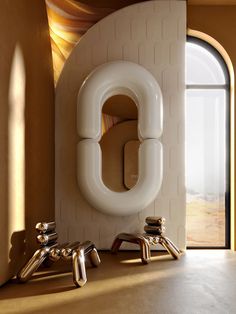 a bathroom with an oval shaped mirror on the wall next to two chrome faucets