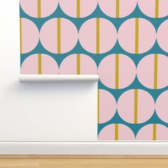 a pink and blue wallpaper with circles on it next to a white shelf in a room