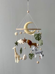 a mobile with animals, giraffes and other things hanging from it's sides