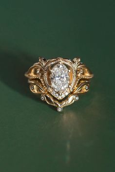 a close up of a gold ring on a green surface with a diamond in the center