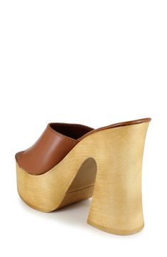 A woodgrain platform and soaring block heel lend scene-stealing height and retro-cool appeal to a slide sandal that will elevate your trendsetting looks. 4" heel; 2" platform Leather upper and lining/synthetic sole Made in Spain Brown Open Toe Clogs With 4-inch Heel, Modern Clogs With Wooden Wedge Heel, Trendy Wedge Heels With Wooden Heel, Trendy Wooden Wedge Heels, Retro Mules With Wooden Heel For Spring, Modern Brown Heels With Stacked Heel, Brown Wooden Platform Heels, Trendy Brown Sandals With Sculpted Heel, Brown High Heel Platform Mules