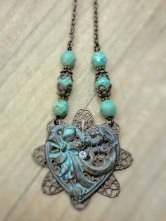 Experience the timeless beauty of our Antiqued Brass Filigree Heart Assemblage Necklace. With vintage romantic Victorian filigree and a stunning patina heart, this necklace is perfect for any occasion. The Czech glass beaded chain adds an extra touch of elegance, making it the perfect gift for someone special. Antiqued brass filigree Antiqued brass heart with patina and rhinestone Faceted Czech glass beads Antiqued brass chain Lobster clasp closure Chain measures 18" Pendant is 3" One of a Kind Vintaj Jewelry, Vintage Assemblage Necklace, Old Jewelry Crafts, Victorian Filigree, Upcycled Vintage Jewelry, Filigree Heart, Brass Filigree, Assemblage Necklace, Assemblage Jewelry