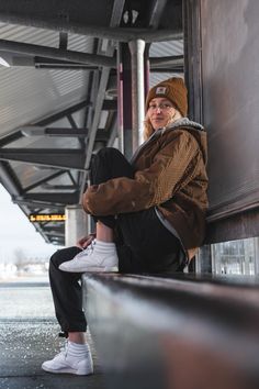 a woman sitting on the side of a building