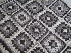 a black and white crocheted blanket on top of a table