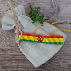 a small beaded object sitting on top of a cloth bag next to a plant