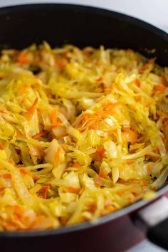 cabbage and carrots cooking in a pan on the stove