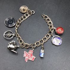 a bunch of different types of buttons on a metal chain with some charms attached to it