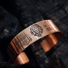 a close up of a bracelet with a lion design on it's back side