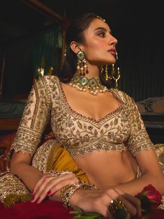 Step into refined elegance with this opulent gold lehenga, a stunning embodiment of artistry and tradition. Crafted from rich raw silk, the lehenga features intricate filigree work that gracefully dances across the fabric like golden vines. Hand-embroidered with vintage gold zari and shimmering sequins, the blouse and lehenga skirt showcase a beautiful romance depicted through floral and bird motifs. Paired with a striking maroon dupatta adorned with a delicate kiran border, this ensemble captures the essence of timeless beauty, making it perfect for any grand occasion. Maroon Dupatta, Gold Lehenga, Lehenga Skirt, Gold Blouse, Bird Motif, Gold Fabric, Sequins Embroidery, Silk Embroidery, Floral Bridal