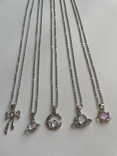 These beautiful necklaces are hand made with a 48cm stainless steel chain. On the chain, hangs a stunning silver plated, iridescent, pink pendant with various unique designs to choose from! It is perfect for daily wear or as a gift to a friend or a loved one!   Styles  ☆ Bella ☆ Comet   ☆ Luna ☆ Astra ☆ Esther  !! These charms have a unique pink colour that changes with different angles and lighting !! ♡ The chain is stainless steel and is approximately 19 inches in length. ♡ The colours may var Cute Silver Clavicle Chain Jewelry, Silver Alloy Heart Pendant Charm Necklace, Cute Silver Charm Necklaces With Clavicle Chain, Heart Shaped Silver Alloy Charm Necklace, Silver Charm Necklace In Alloy, Silver Crystal Pendant Necklace With Charms, Cute Silver Jewelry With Adjustable Chain, Silver Heart-shaped Crystal Necklace With Clavicle Chain, Cute Metal Necklaces For Gifts